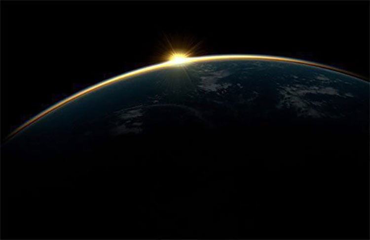 Sunrise over Earth’s horizon seen from space with dark sky background.