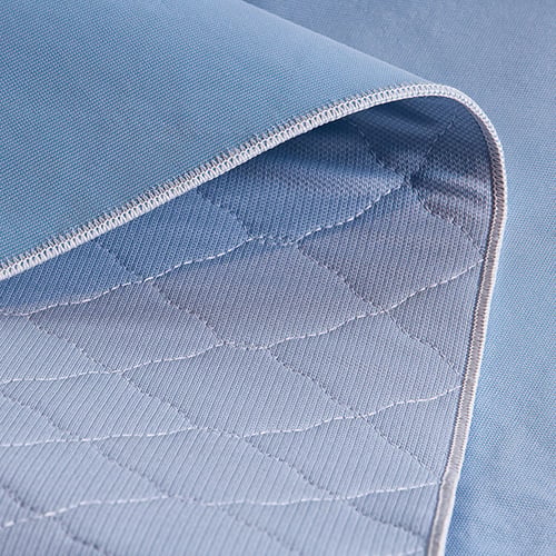 Blue quilted reusable underpad with folded corner detail