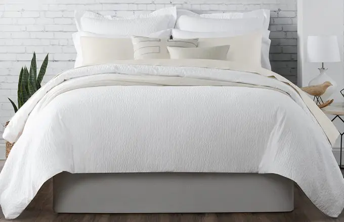 Image of well made bed with Standard Textile pillows, sheets, and mattress encasement.