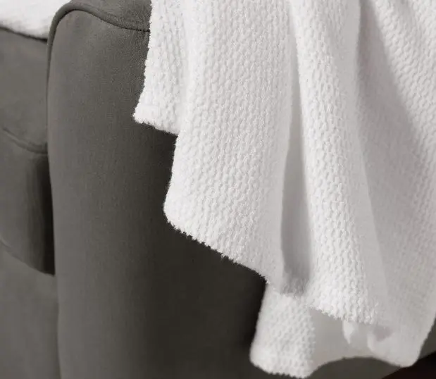 Detiail of a white Lynova all season blanket draped over a chair.