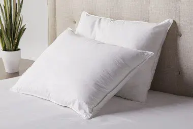 Hotel Chamber pillows neatly stacked on a guest bed.