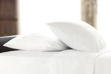 Two hotel chamber pillows on a plush guest bed.