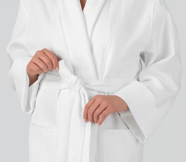 Detail of a model's hands tightening the belt on the Logan Bathrobe. This robe is a popular unisex waffle robe. Heidi Weisel robes are uniquely designed with artistic flare.