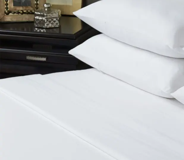 Detail of Vidori sheets on a bed. The pillow cases of these quality sheets have the unique envelope closure.