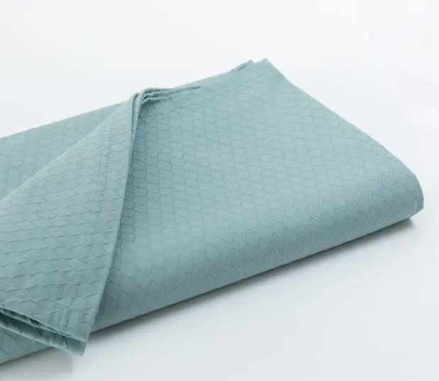Seen here folded is a Gemstone healthcare bedspread in Sage. This bedspread has a diamond design.
