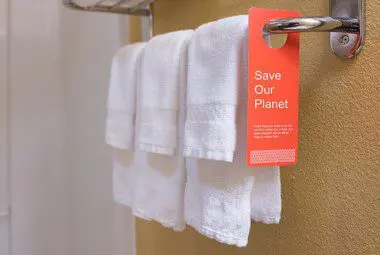 A hotel towel rack with a hand tag that says 