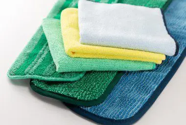 Various microfiber cleaning products stacked neatly on a table.