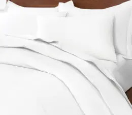 A Paragon 100% Cotton duvet cover sits atop a plush hotel guest bed.