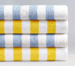 A stack of blue and yellow cabana stripe pool towels.
