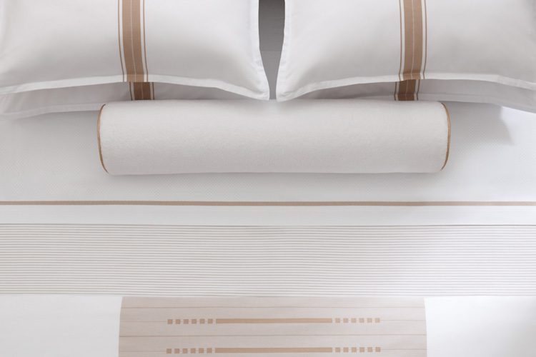 An overhead view of a luxury hotel bed featuring Todd Avery Lenehan sheeting and pillowcases.