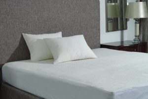 2 allerease platinum pillows laying against a hotel bed headboard