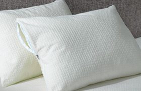 AllerEase Platinum Pillow Protectors stacked on a hotel bed