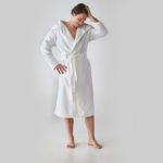 A man posing in a Heidi Weisel Bailey hotel robe.