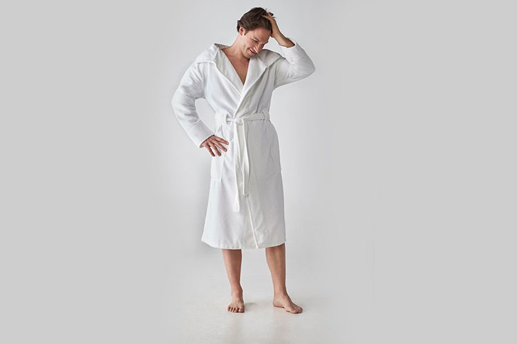 A man posing in a Heidi Weisel Bailey hotel robe.
