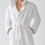 A man wearing a Heidi Weisel Bailey hotel robe.
