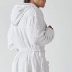 A man wearing a Heidi Weisel Billy hotel robe.