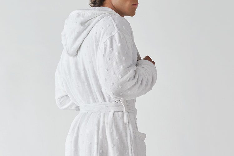 A man wearing a Heidi Weisel Billy hotel robe.
