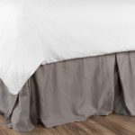 Image of a bed with a traditional messy bed skirt.