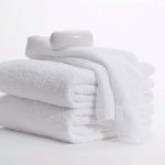 A bar of soap rests atop a folded stack of Classic Dobby bath towels.