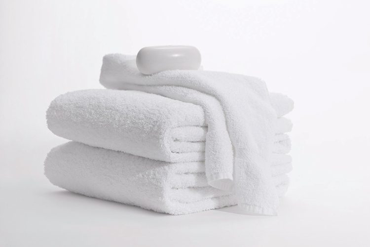A bar of soap rests atop a folded stack of Classic Dobby bath towels.