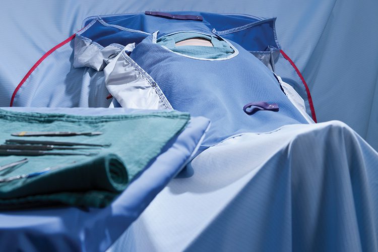 A staged surgical scene featuring ComPel Surgical Drapes and Covers.