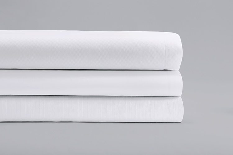 Stack of three ComforTwill Sheets in microcheck, solid, and stripe