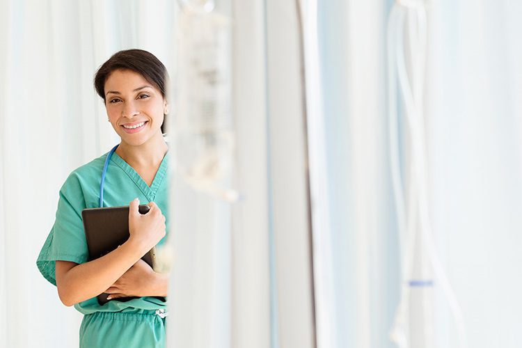A female doctor standing, partially obscured by cubical curtains.