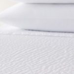 A detail shot of a bed featuring a Cumulus top cover.