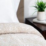 Image is of a beige custom healthcare bedspread. The fabric is Tudor.