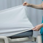 FDA-cleared DermaTherapy® therapeutic sheet being placed on a hospital bed by a clinician