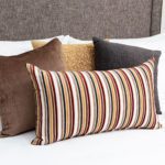 Four decorative throw pillows arranged on a hotel bed.