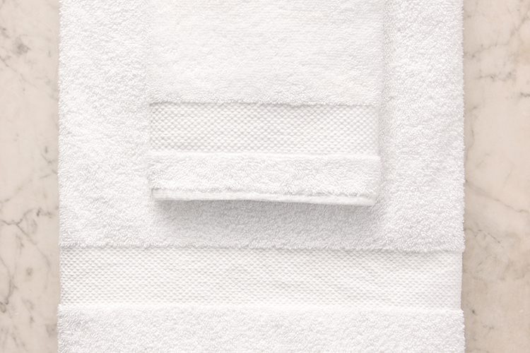 Detail of A stack of white EuroClassique hotel bath towels.