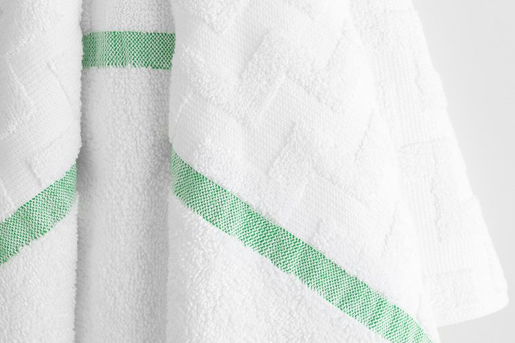 Close-up for Eurospa Lounge Chair bulk pool towel with a green stripe