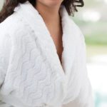 A woman wearing a EuroSpa robe at a hotel pool.