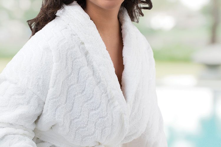 A woman wearing a EuroSpa robe at a hotel pool.