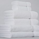 A stack of white EuroTouch towels for hotels.