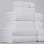A stack of white EuroTouch towels for hotels.