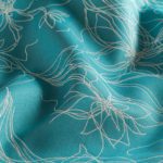 Sunbrella Devou is an outdoor fabric. The pattern resembles abstract flowers the field is turquoise.