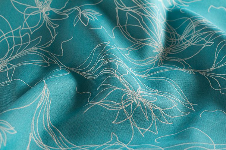 Sunbrella Devou is an outdoor fabric. The pattern resembles abstract flowers the field is turquoise.