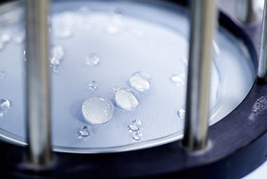 A close up image of a machine testing the effectiveness of fabrics to withstand liquids moving through them.