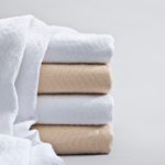 A stack of herringbone blankets in bleached and natural.