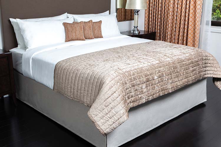 Custom Top of Bed and Bed Skirt: Pillows in Nova/Terra Cotta; Quilted Image of a made bed with Throw in Jewel/Pewter; Top Cover in Savannah/White; Headboard in Montauk/Mocha; Bed Skirt in Zircon/Porpoise
