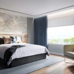 A luxury hotel room, featuring a well-made bed, custom printed wall covering, and a large window with stylish window treatments.