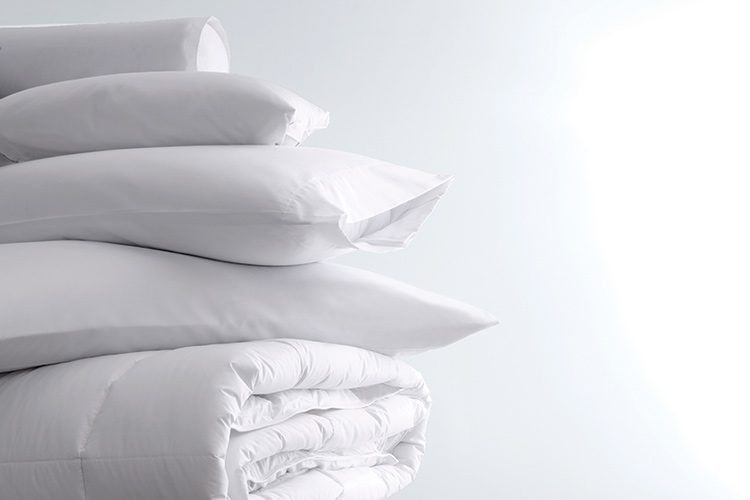 A stack of pillows and LuxSoft Comforter.