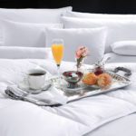 Breakfast in bed tray on LuxSoft comforter and assorted pillows.