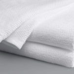 A folded Lynova blanket with edge detail in white.