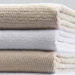 A stack of Lynova blankets in white and champagne.