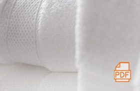 A stack of folded Lynova bath towels with a PDF icon superimposed to indicate a link to a brochure.
