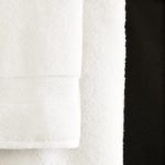 A Lynova bath towels hanging from a towel rod.