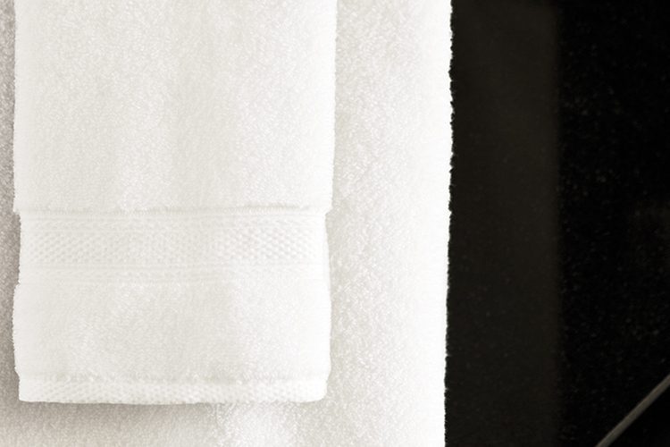 A Lynova bath towels hanging from a towel rod.